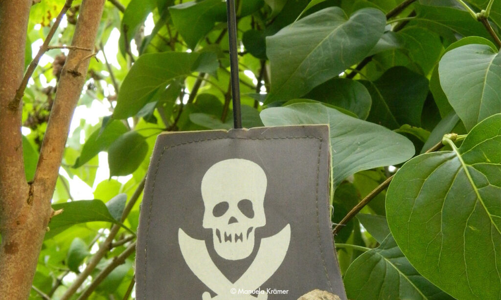 Piratenflagge vor grünen Blättern