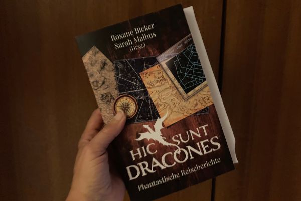 Hand hält Buch mit vielen Kurzgeschichten.