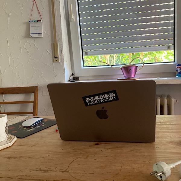 12-von-12-laptop Laptop mit Aufkleber "Love poetry, hate racism" aufgeklappt auf Küchentisch.